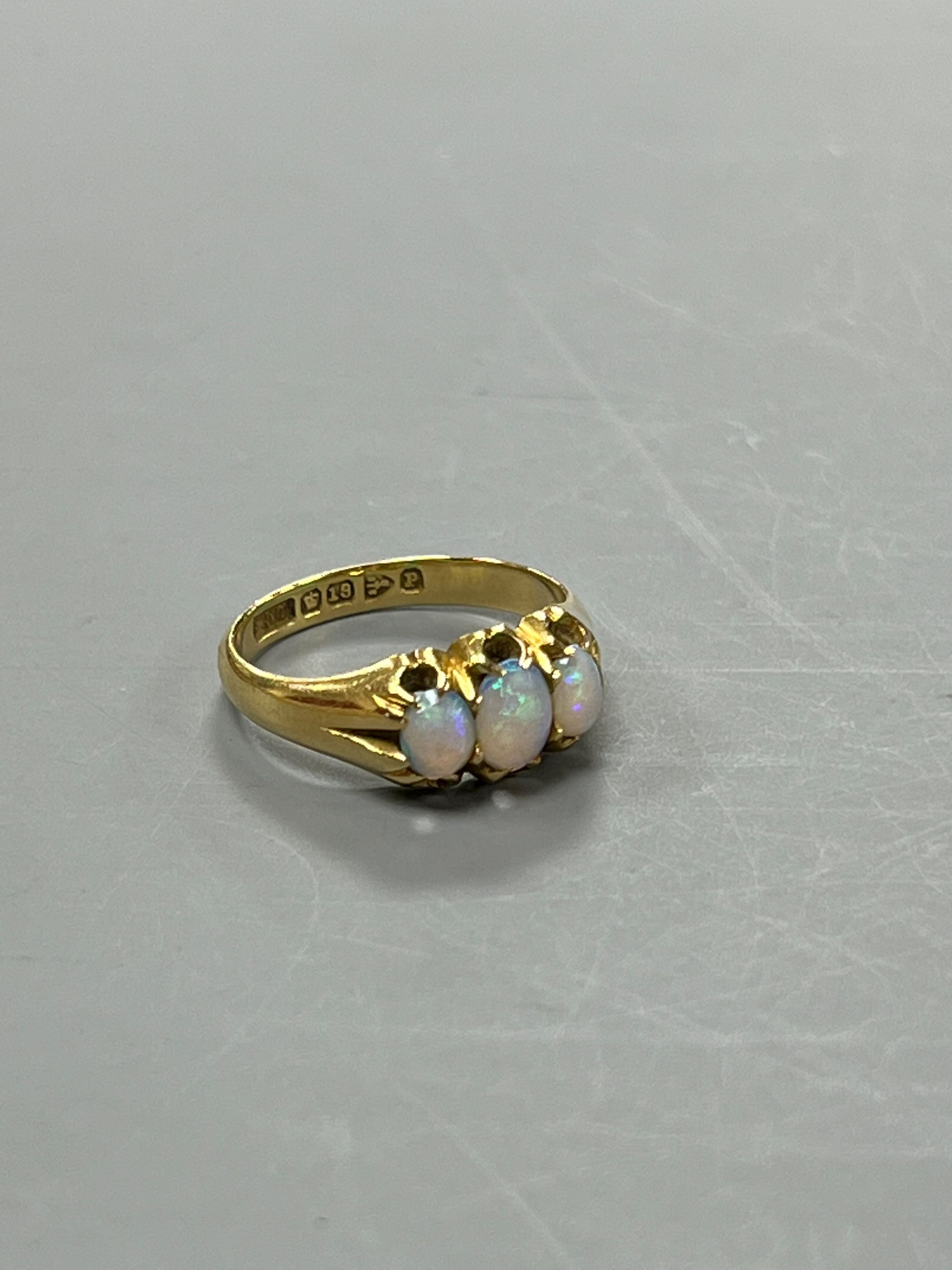 A late Victorian 18ct gold and claw set three stone white opal ring, size M, gross weight 4.1 grams.